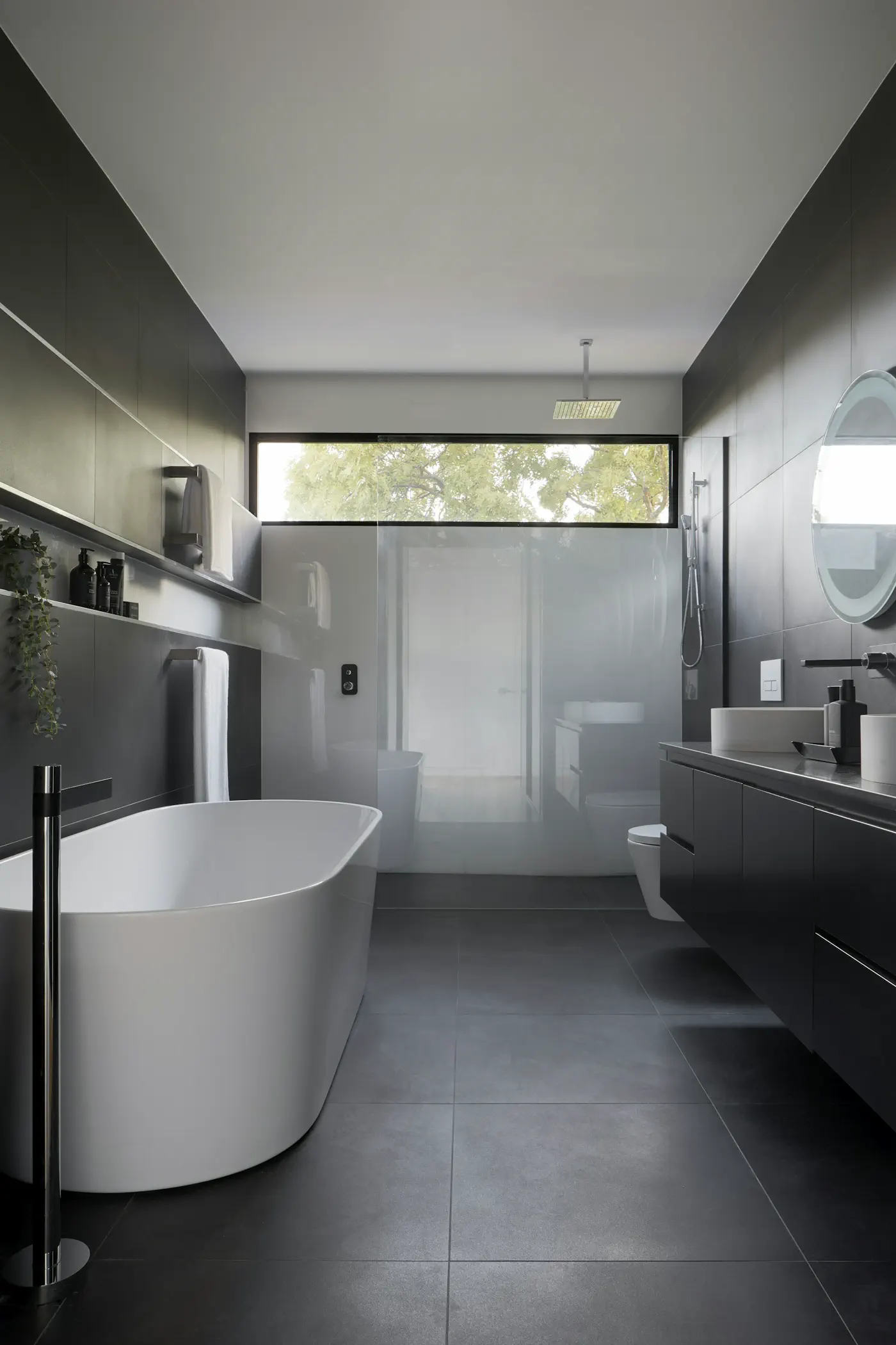 Unsplash (bathroom still) Marble hotel bathroom with folded towels and a clear wet-room finish — editorial still